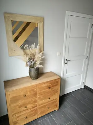 a wooden dresser with a mirror and a vase on it at Vakantiewoning De Zilverberk in Geraardsbergen