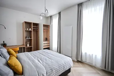 a bedroom with a bed and a large window at Urban Chic Apartment in the Heart of Mechelen in Mechelen