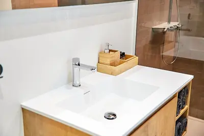 a bathroom with a white sink and a shower at Urban Chic Apartment in the Heart of Mechelen in Mechelen