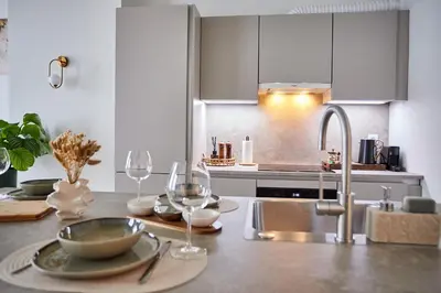 a kitchen with a sink and a table with wine glasses at Urban Chic Apartment in the Heart of Mechelen in Mechelen