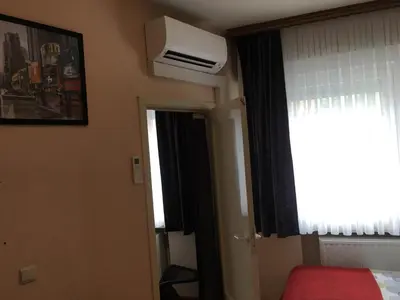 a bedroom with a bed and a window and a air conditioner at One-bedroom Apartment near Atomium in Brussels
