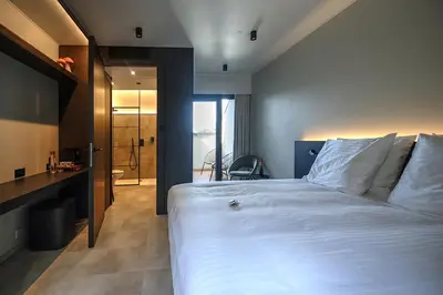 a bedroom with a large white bed and a bathroom at Hotel Hallensis in Halle