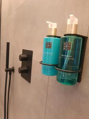 two bottles ofodorizers on a wall in a bathroom at Hotel Hallensis in Halle