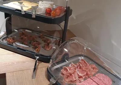 a tray of food with meat and tomatoes on a table at Hotel Hallensis in Halle
