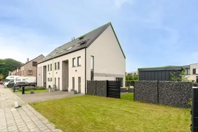 a white house with a fence in front of it at Espace moderne pouvant accueillir 3 personnes in Vilvoorde