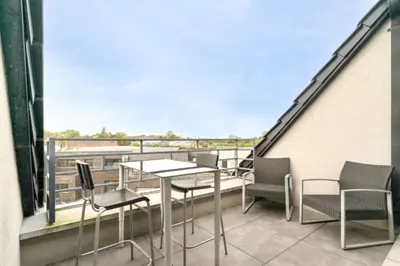 a balcony with a table and chairs on a building at Espace moderne pouvant accueillir 3 personnes in Vilvoorde