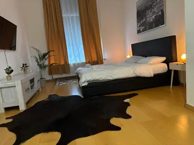 a bedroom with a bed with a black rug on the floor at L&L Residence in Brussels