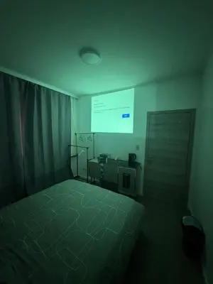 a bedroom with a bed and a projection screen at Sweetroom in Brussels