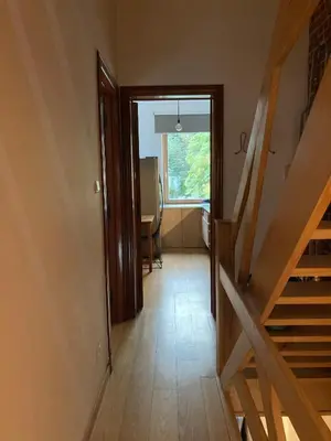 a hallway with a staircase and a room with a window at Nice flat near Brussels in Dilbeek