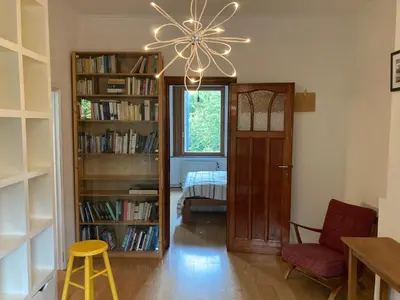 a living room with a chandelier and bookshelves at Nice flat near Brussels in Dilbeek