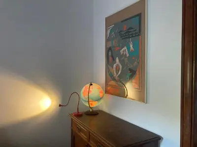 a lamp sitting on top of a dresser under a painting at Nice flat near Brussels in Dilbeek