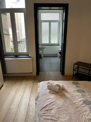 a bedroom with a bed with a pair of shoes on it at Bruxelles midi flat in Brussels