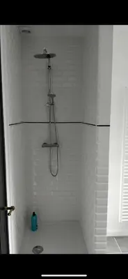 a shower in a bathroom with white tiles at Bruxelles midi flat in Brussels