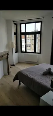 a bedroom with a bed and a large window at Bruxelles midi flat in Brussels