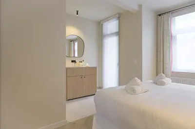 a white bedroom with a bed and a sink at SHWAY - The Printing Press in Antwerp