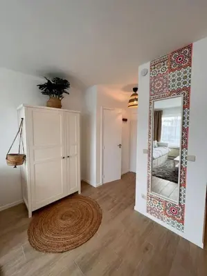 a living room with a mirror and a rug at Flat moderne et lumineux in Brussels