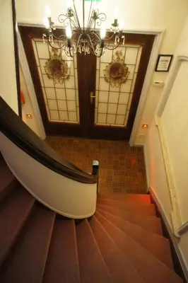 a hallway with a staircase with a chandelier at J and R Brussels City Apartment in Brussels