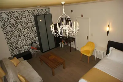 a living room with a couch and a chandelier at J and R Brussels City Apartment in Brussels