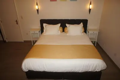a large bed with white sheets and pillows in a room at J and R Brussels City Apartment in Brussels