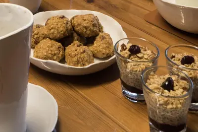 a table with a bowl of oatmeal and a plate of cookies at B&B De Oude Berg in Mol