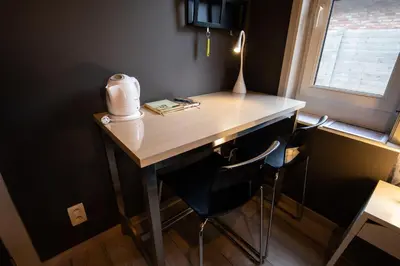 a desk with two chairs and a lamp on it at B&B De Oude Berg in Mol