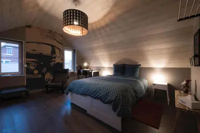 a bedroom with a bed and a truck on the wall at B&B De Oude Berg in Mol