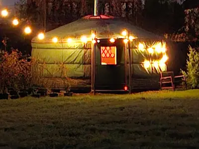 a yurt with christmas lights in a yard at night at Yurt 2-4p in Ravels