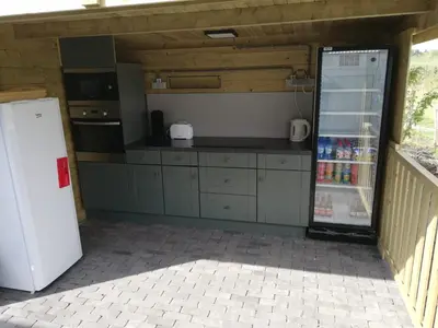 a kitchen with a refrigerator and a counter with drinks at Yurt 2-4p in Ravels