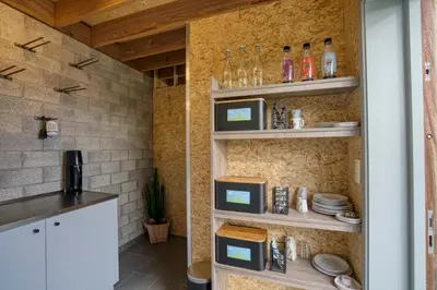 a kitchen with white shelves with dishes on them at Yurt 2-4p in Ravels