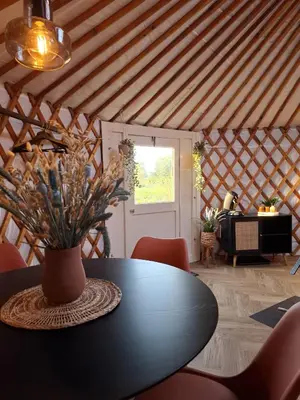 a room with a table with a vase on it at Yurt 2-4p in Ravels