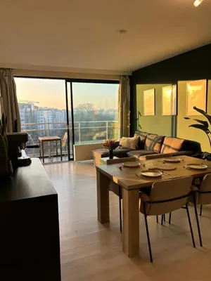 a living room with a table and a couch at Central Apartment with City Park View and Terrace in Antwerp