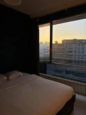 a bedroom with a bed and a large window at Central Apartment with City Park View and Terrace in Antwerp