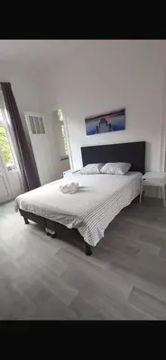 a white bedroom with a large bed in a room at Brussels city center apartment in Brussels