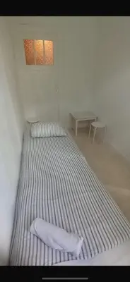 a large bed in a white room with a table at Brussels city center apartment in Brussels