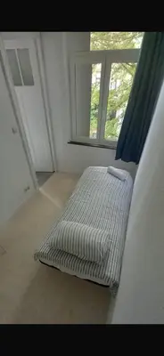 a bed sitting in a room with a window at Brussels city center apartment in Brussels