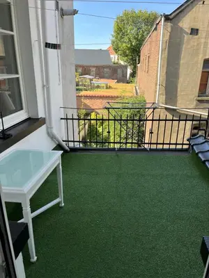 a balcony with a green floor and a table at Brussels city center apartment in Brussels