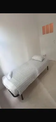 a unmade bed in a white room in a room at Brussels city center apartment in Brussels