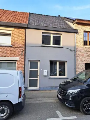 two cars parked in a parking lot in front of a house at Gezellige Rijwoning met tuin in Werkstede