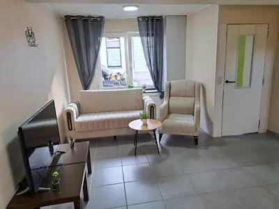 a living room with a couch and chairs and a table at Gezellige Rijwoning met tuin in Werkstede