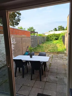 a white table and chairs on a patio at Gezellige Rijwoning met tuin in Werkstede