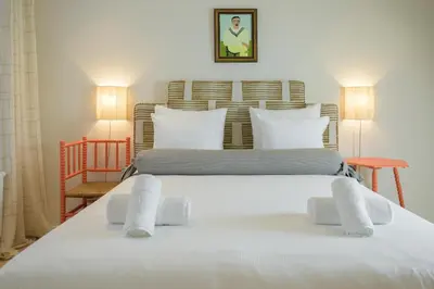 two beds in a room with white sheets and pillows at SHWAY - The Book Binder in Antwerp