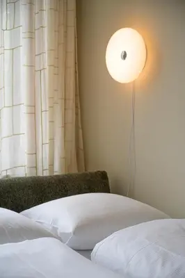 a bedroom with a bed and a light on the wall at SHWAY - The Proof Reader in Antwerp