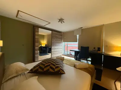 a bedroom with a bed and a desk in a room at Dreamland in Zaventem