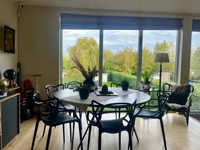 a dining room table with chairs and a large window at Dreamland in Zaventem