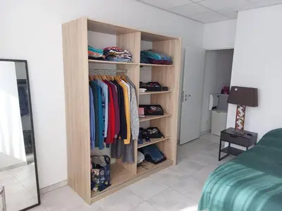 a room with a wooden closet with clothes at LUX Appartment in BXL Center in Brussels