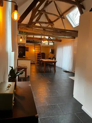 a living room with a table and a kitchen at Melkhuisje in Dendermonde