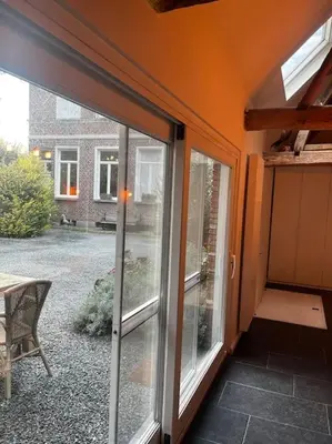 a sliding glass door of a house with a patio at Melkhuisje in Dendermonde