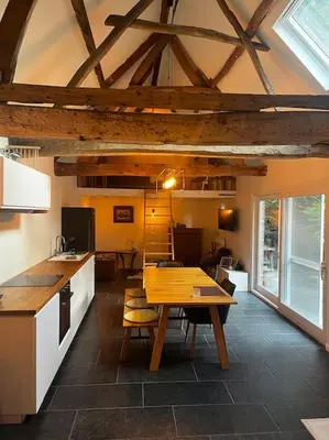 a kitchen with a wooden table in a room at Melkhuisje in Dendermonde