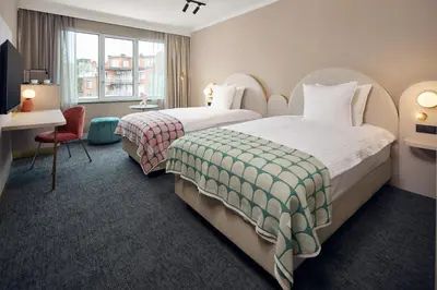 a hotel room with two beds and a desk at Van der Valk Hotel Park Lane Antwerpen in Antwerp