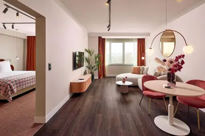 a hotel room with a bed and a living room at Van der Valk Hotel Park Lane Antwerpen in Antwerp